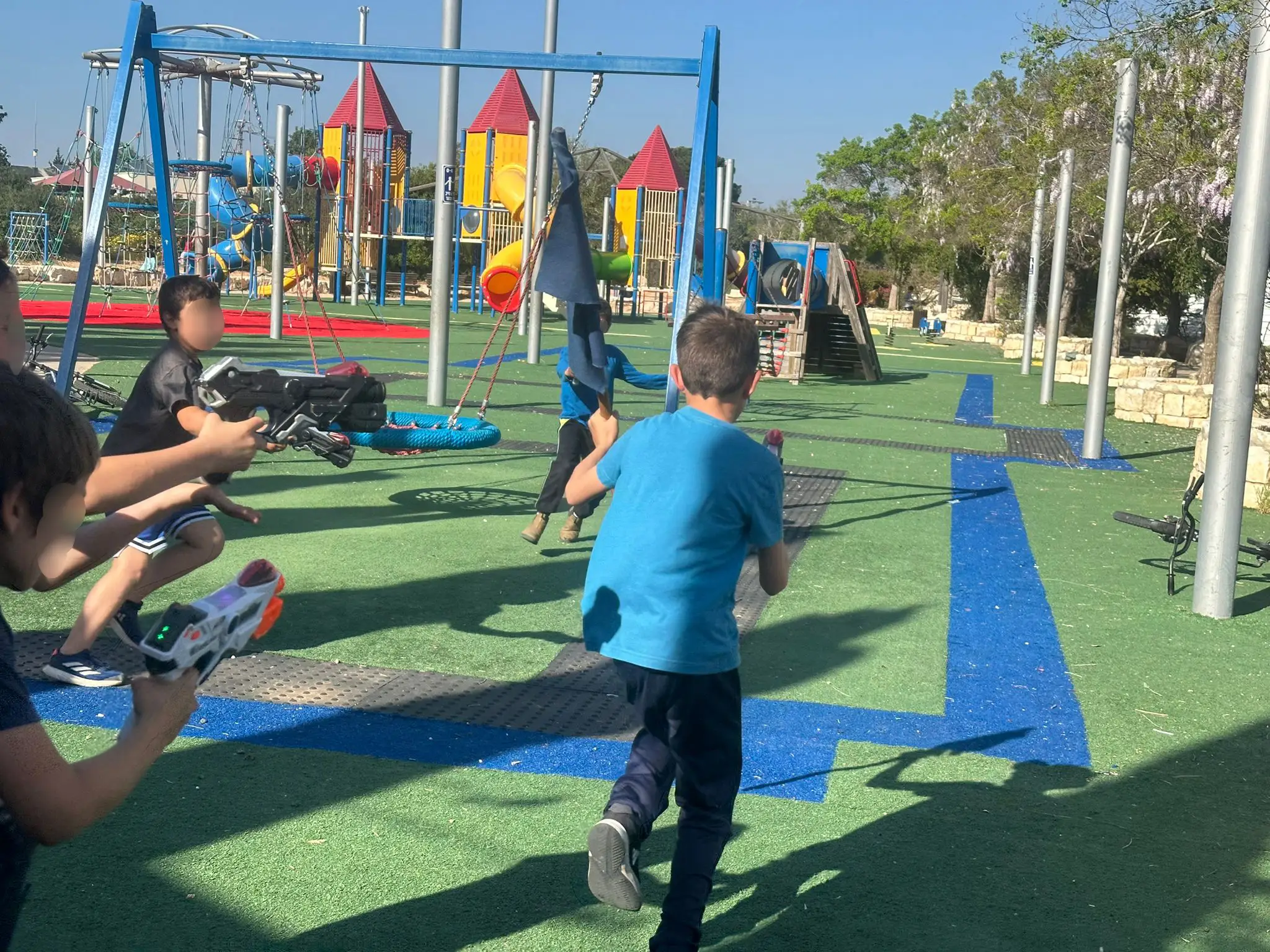 ילדים רצים ומתחבאים עם רובי לייזר במגרש משחקים